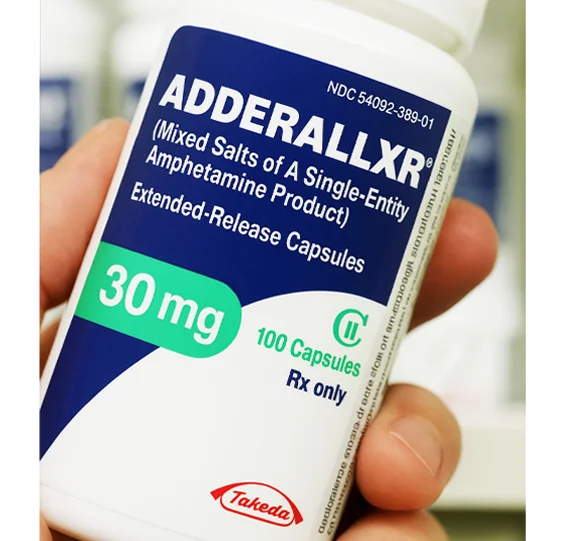 Изображение флакона аддералл в руке у фармацевта